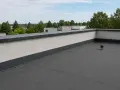 Płaski dach z attyką, czyli nadbudową ściany na krawędzi dachu, chroniącą przed wiatrem i deszczem.