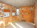 Rozpoczyna się instalacja elektryczna w domu. Widoczne przewody, puszki i oznaczenia na ceglanych ścianach.