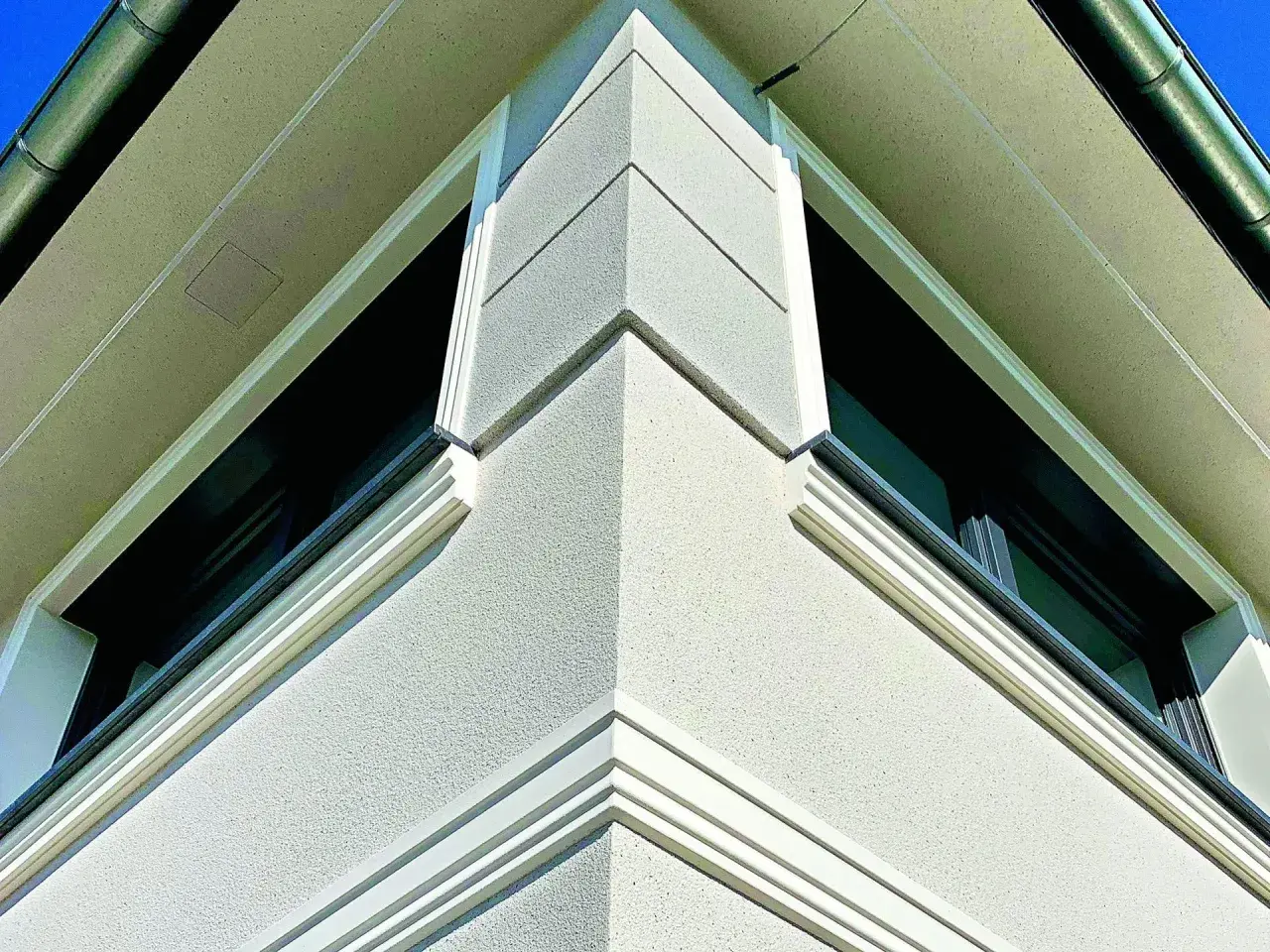 Elegancki gzyms co to? Detal architektoniczny zdobiący narożnik budynku, podkreślający jego nowoczesny styl.