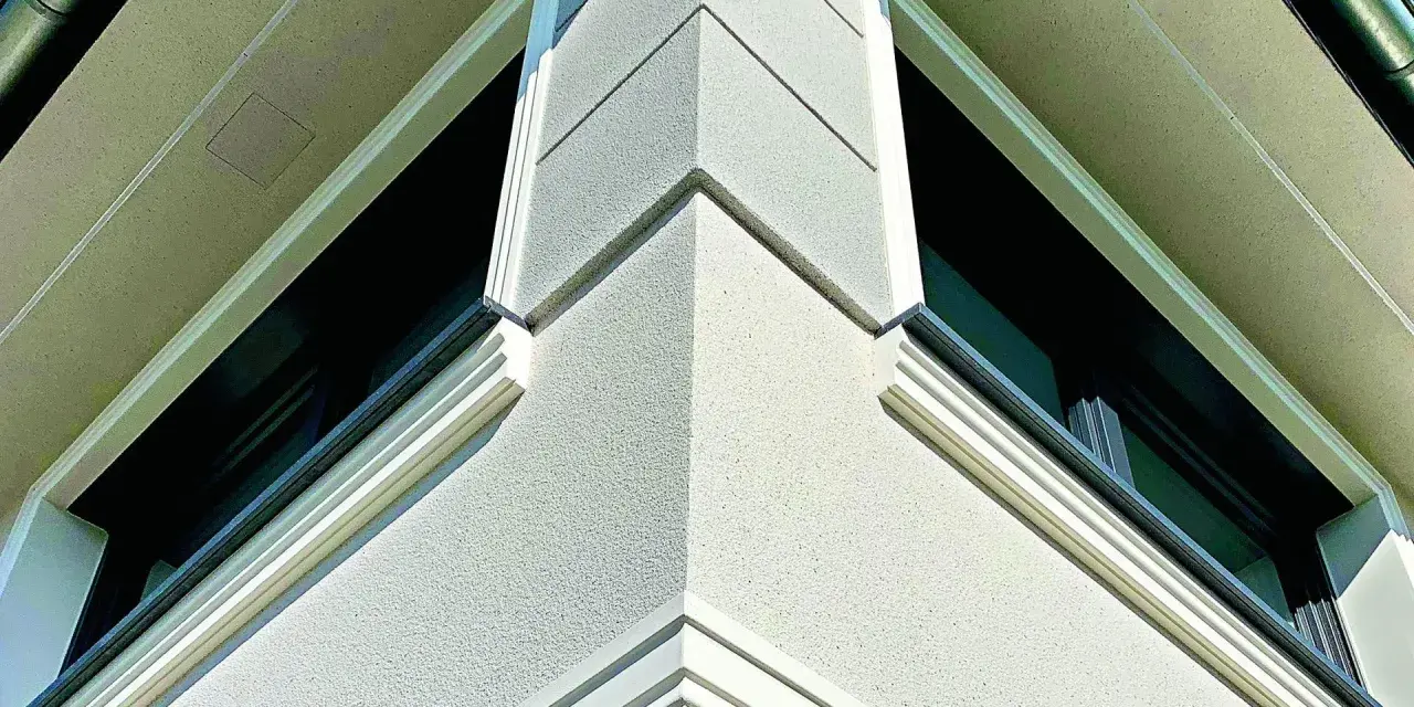 Elegancki gzyms co to? Detal architektoniczny zdobiący narożnik budynku, podkreślający jego nowoczesny styl.