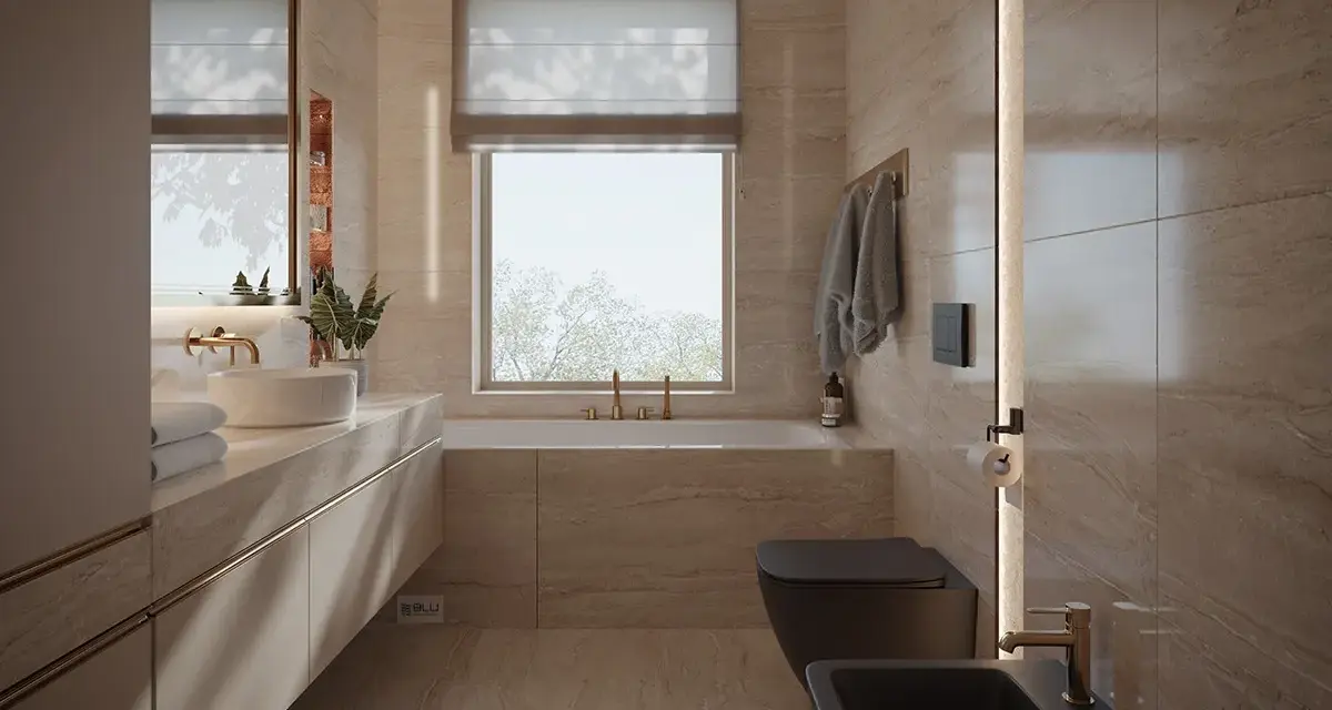 Elegancka łazienka z oknem na wprost drzwi, wanna, czarna miska WC i bidet, kamienne płytki, złote baterie.