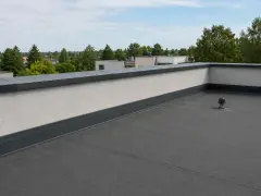 Płaski dach z attyką, czyli nadbudową ściany na krawędzi dachu, chroniącą przed wiatrem i deszczem.