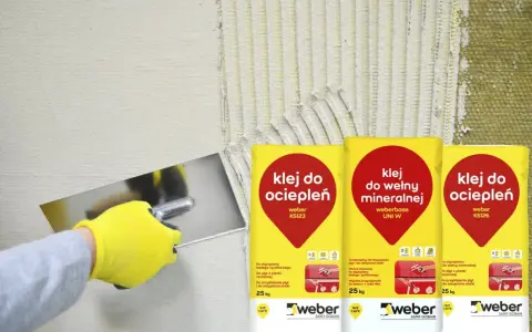 Rękawica w żółtej rękawicy nakłada klej na ścianę. Obok worki z napisem "klej do ociepleń" – idealny, by przykleić styropian do blachy.