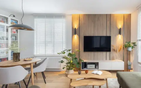 Przytulny salon w domu z drewnianą ścianą RTV, wygodną kanapą i jadalnią.
