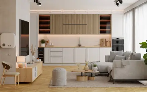 Jak urządzić mały salon z aneksem: jasne meble, wygodna sofa, drewniane akcenty i funkcjonalna zabudowa kuchenna tworzą przytulną przestrzeń.