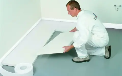 Pracownik układa biały styropian na podłogę, przygotowując izolację. To dobry wybór, jaki styropian na podłogę wybrać.
