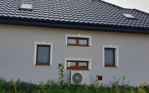 Elegancki gzyms zdobi okna domu, nadając mu stylowy wygląd.