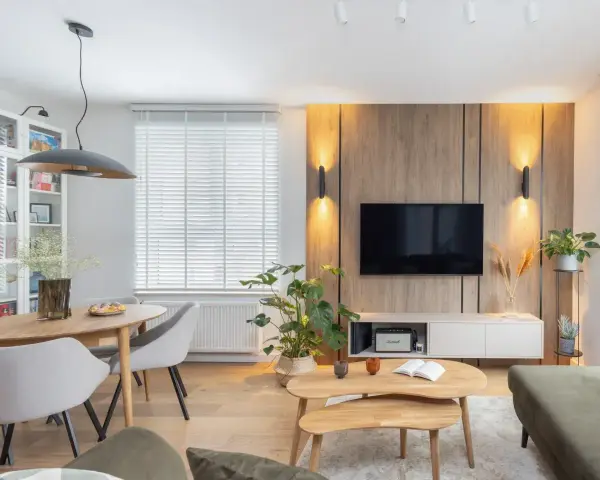 Przytulny salon w domu z drewnianą ścianą RTV, wygodną kanapą i jadalnią.