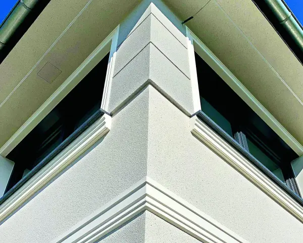 Elegancki gzyms co to? Detal architektoniczny zdobiący narożnik budynku, podkreślający jego nowoczesny styl.