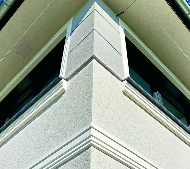 Elegancki gzyms co to? Detal architektoniczny zdobiący narożnik budynku, podkreślający jego nowoczesny styl.