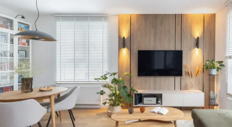 Przytulny salon w domu z drewnianą ścianą RTV, wygodną kanapą i jadalnią.